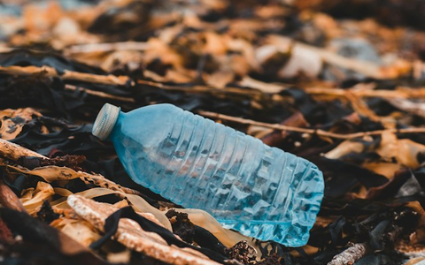 Botol plastik bekas tergeletak di antara sampah